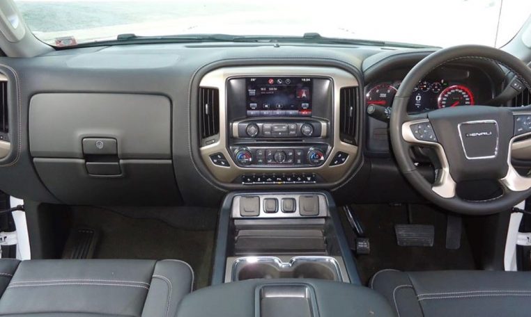 Modern vehicle dashboard and steering wheel interior view.