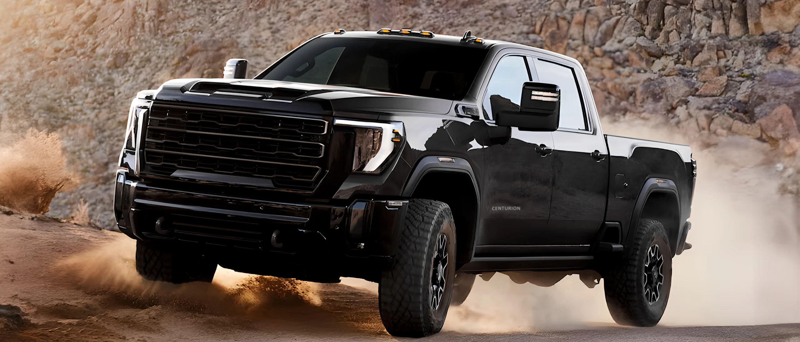 gmc yukon denali speeding across desert track with autogroup international's enturion B6 armour kit installed