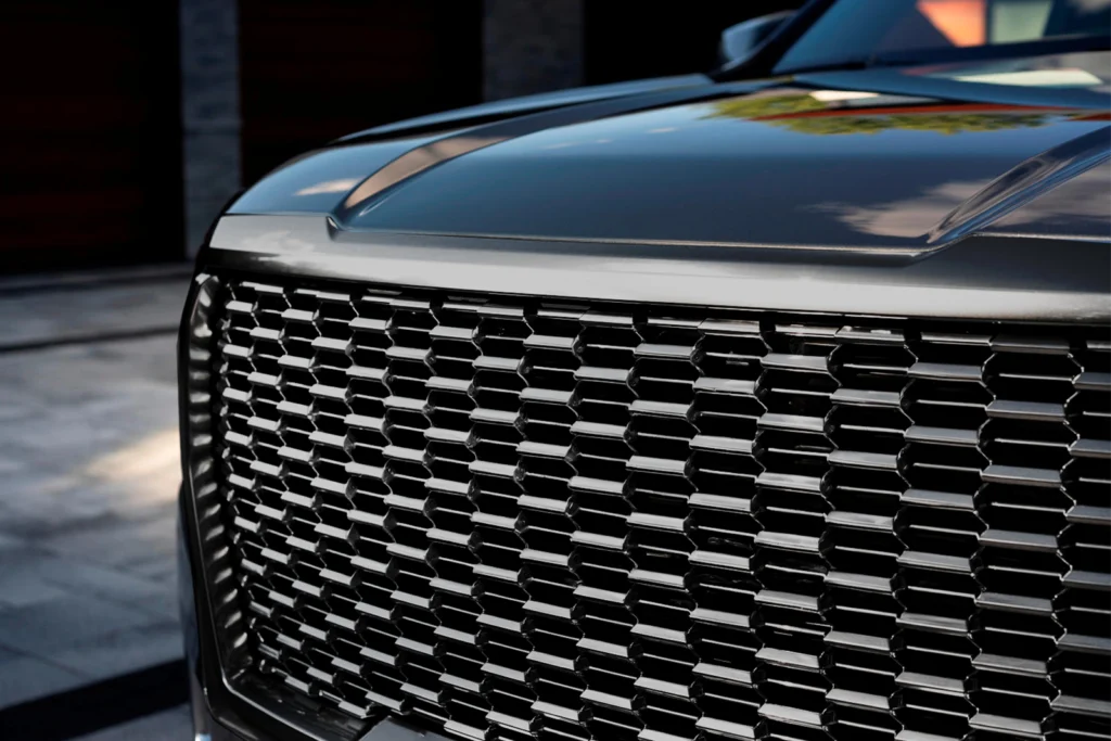 Close-up of luxury car's black grille detailing.