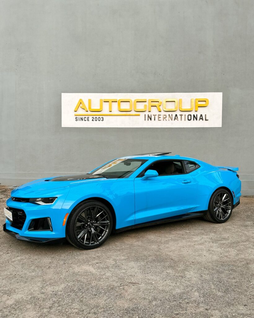 Blue sports car at AutoGroup International storefront