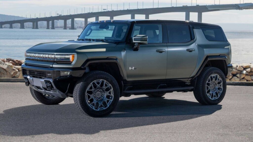 Modern electric SUV parked by ocean bridge.