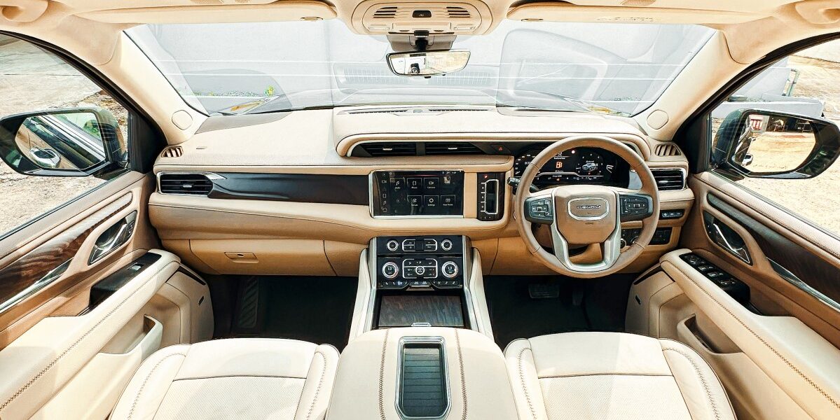 Luxurious car interior with cream leather seats and dashboard.