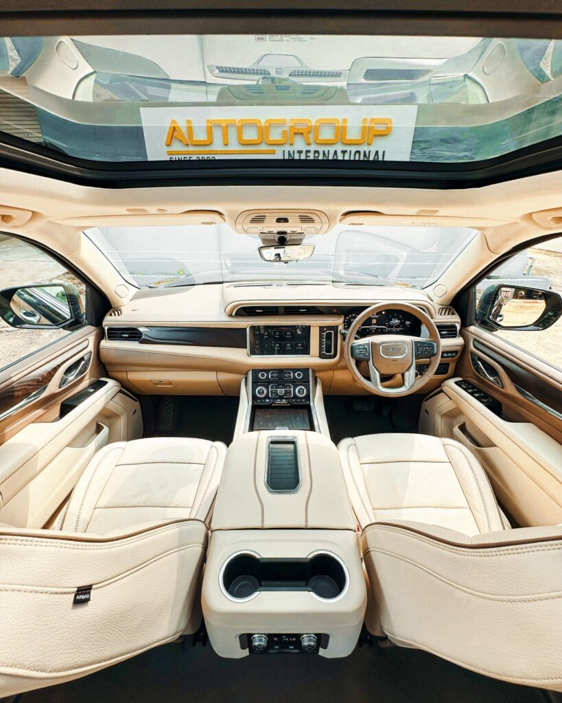 Luxurious car interior with cream leather seats and dashboard.