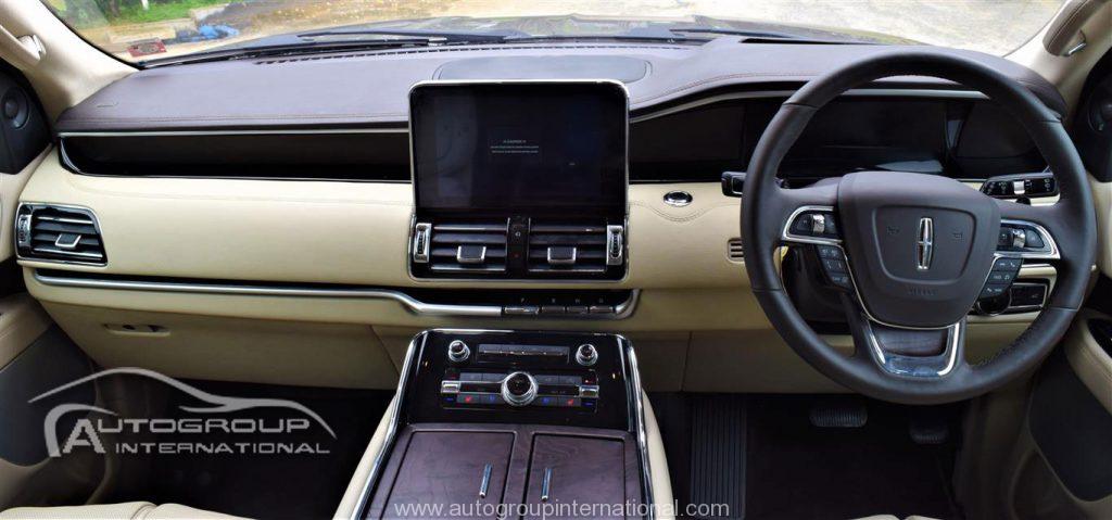 Luxury car interior with beige leather and modern dashboard.
