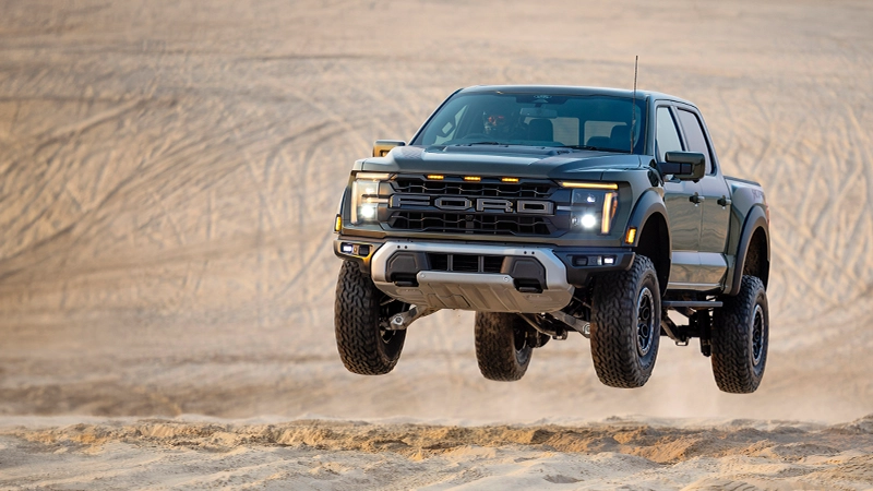 Ford F150 Raptor speeding through desert flying off ground in right hand drive by Autogroup international