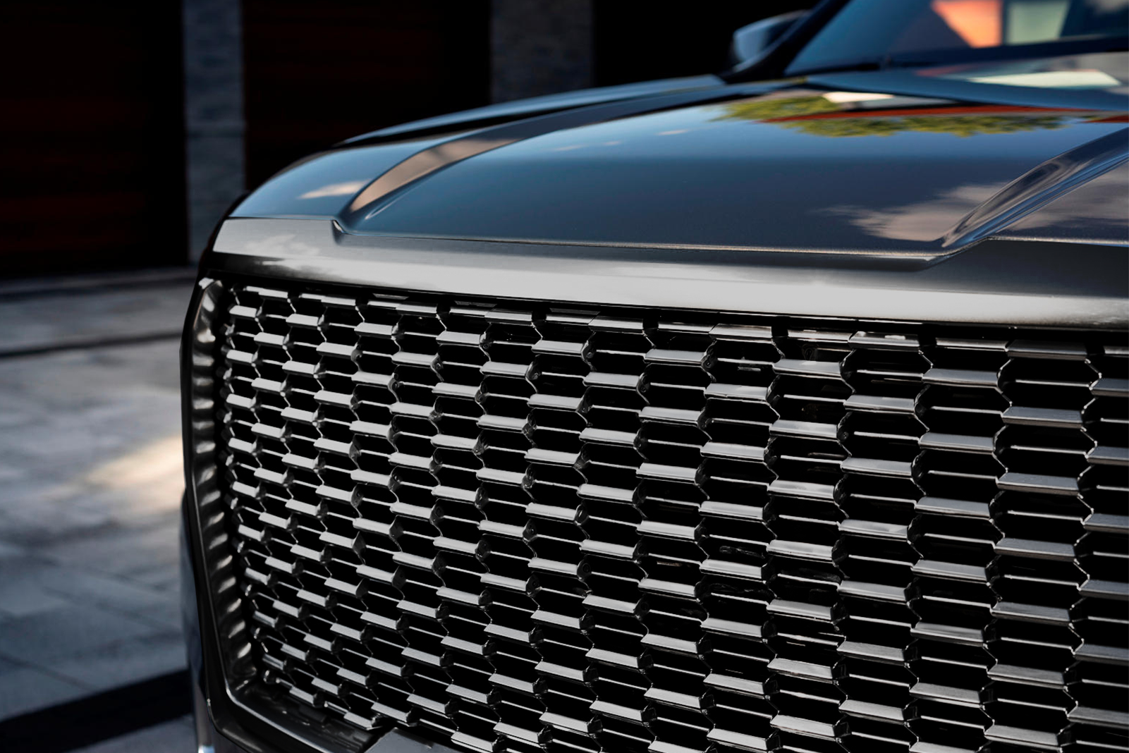 Close-up of a luxury car's black grille.