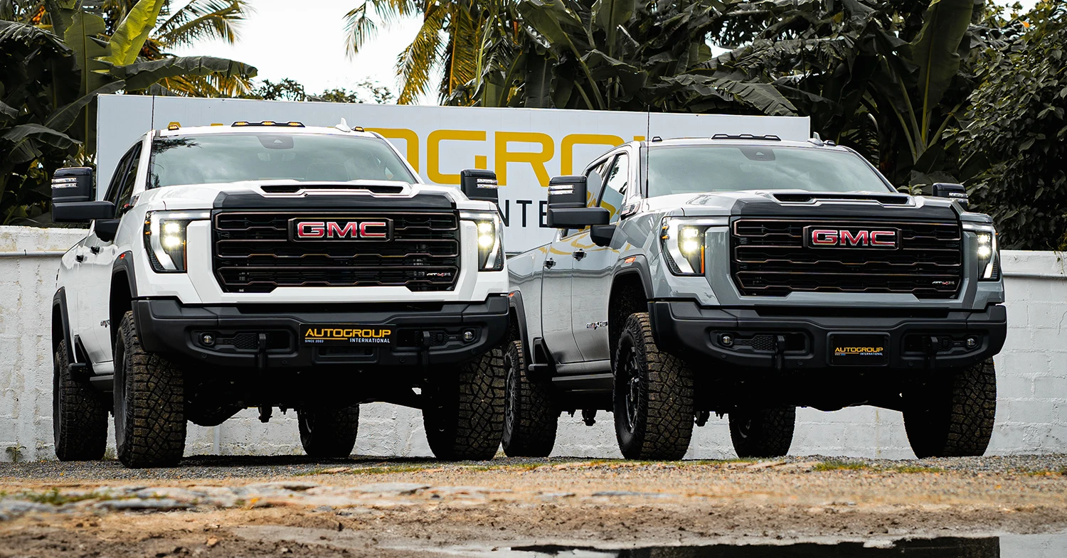 a white and grey 2024 GMC Sierra 2500HD AT4X in Right hand Drive parked next to each other