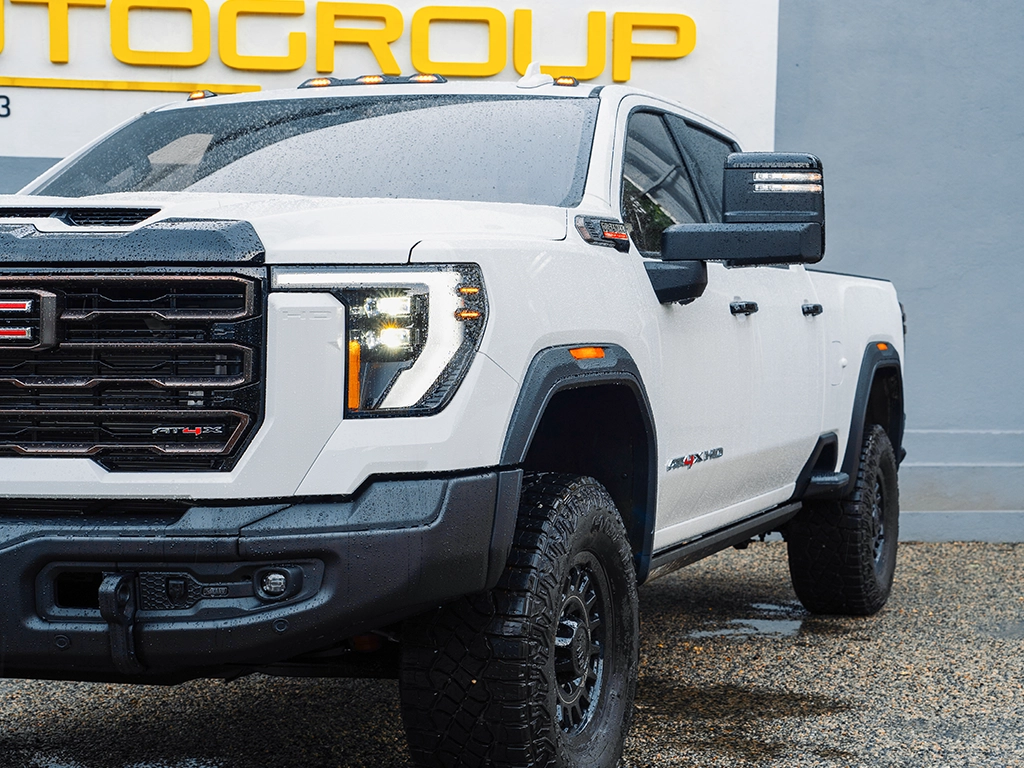 a white 2024 GMC Sierra 2500HD AT4X in Right hand Drive front 3/4 quarter panel