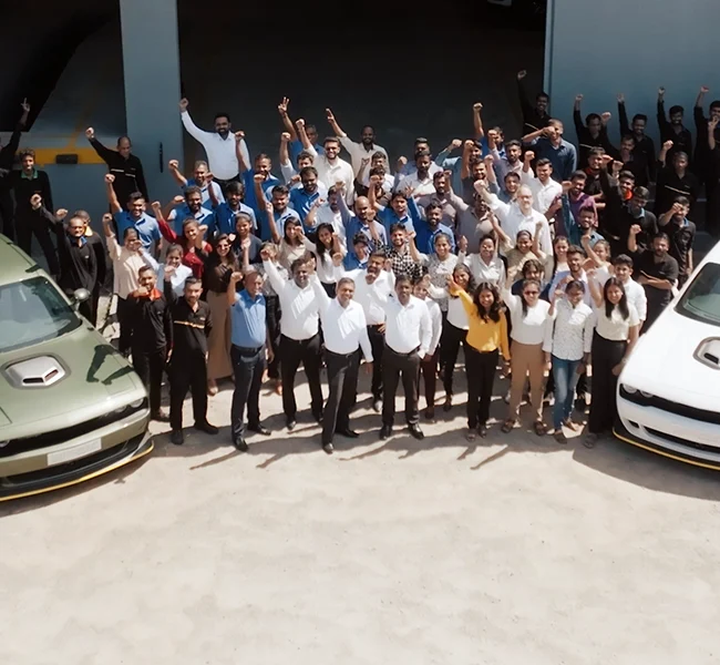 the team at autogroup international standing in group shot out front of factory