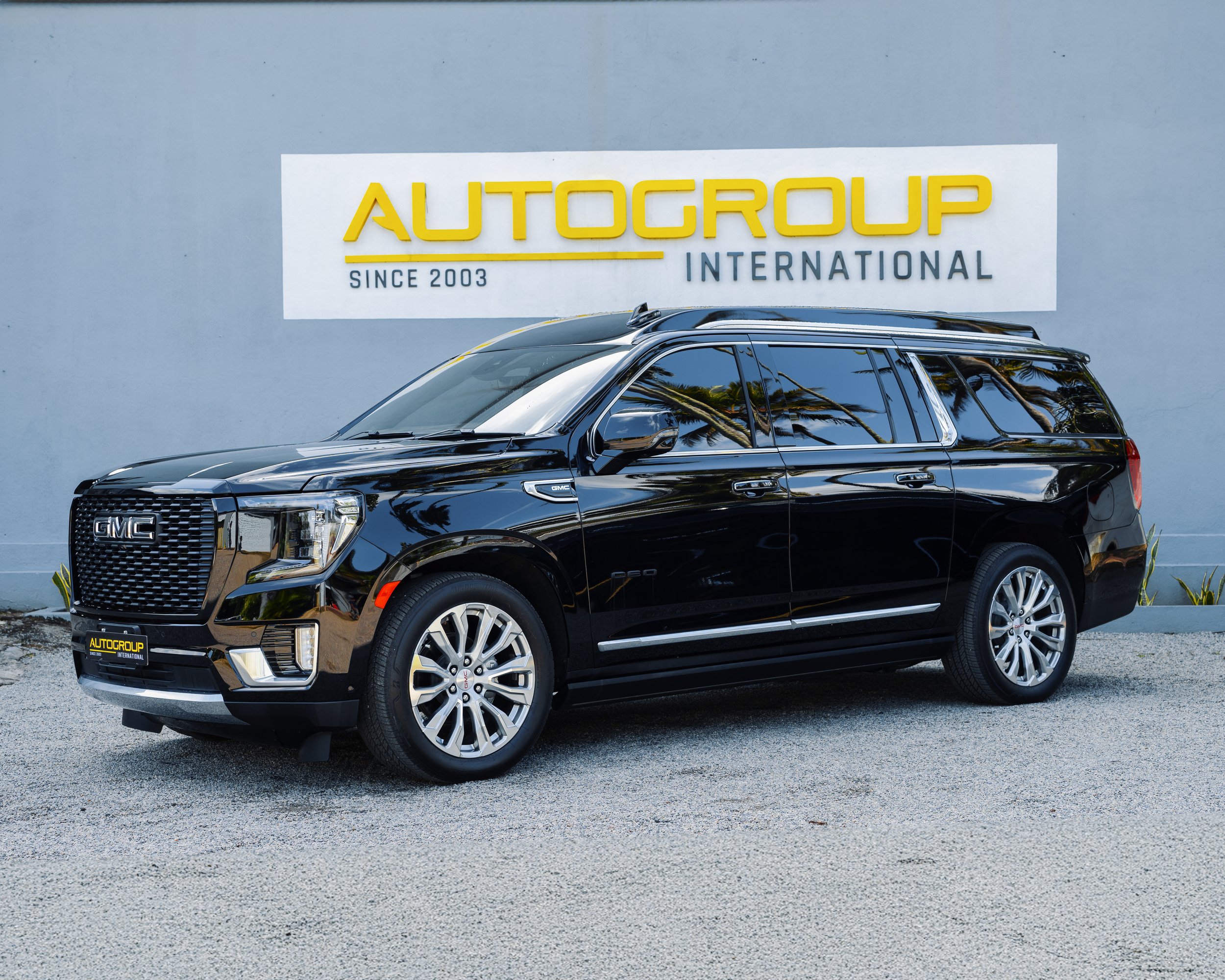 Black GMC SUV in front of AutoGroup International sign