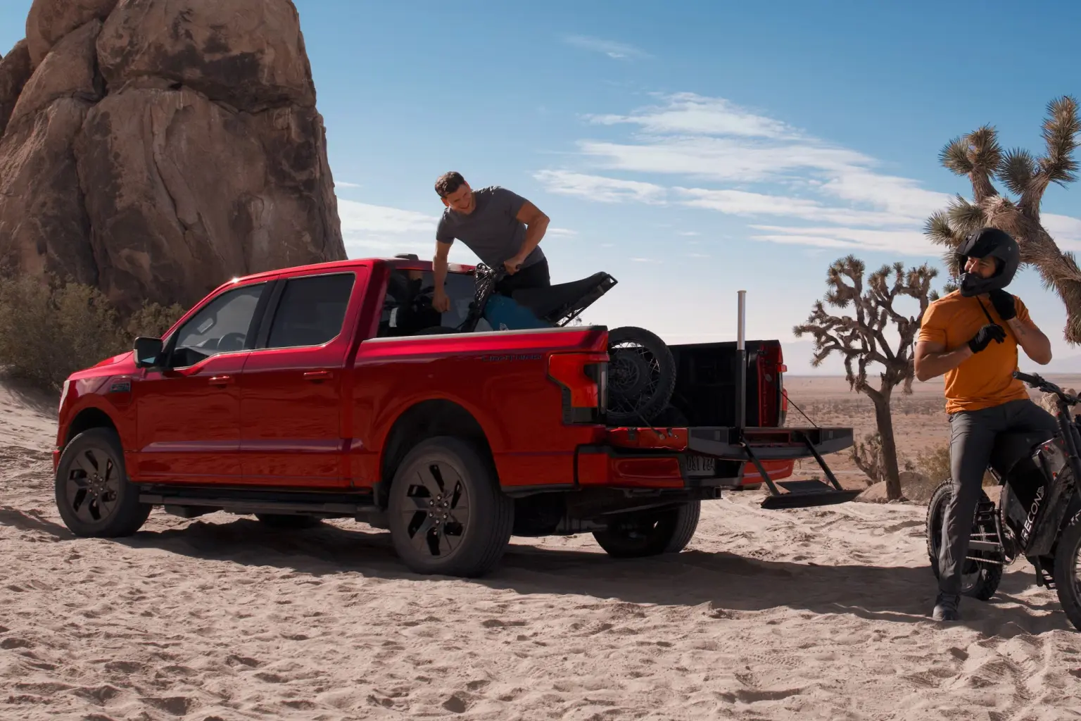 2026 Ford F 150 Lighting truck loading dirt bikes in desert.