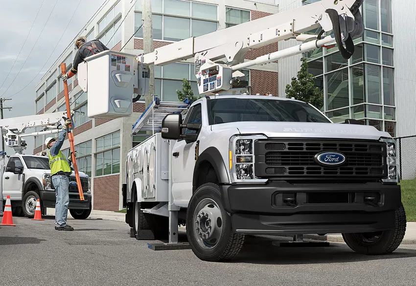 Workers Ford Super Duty F 550 utility truck for power line maintenance