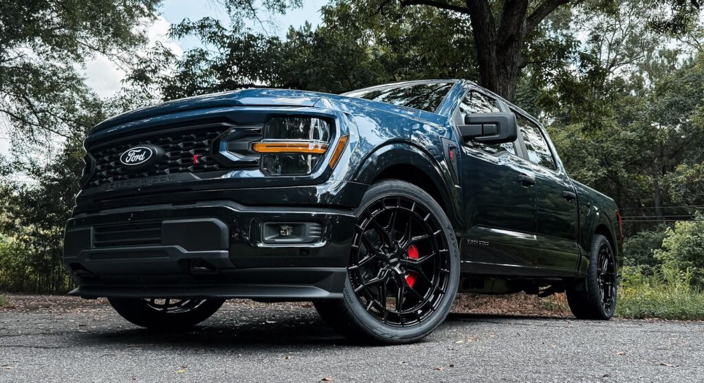 Black Ford pickup truck parked outdoors on asphalt road
