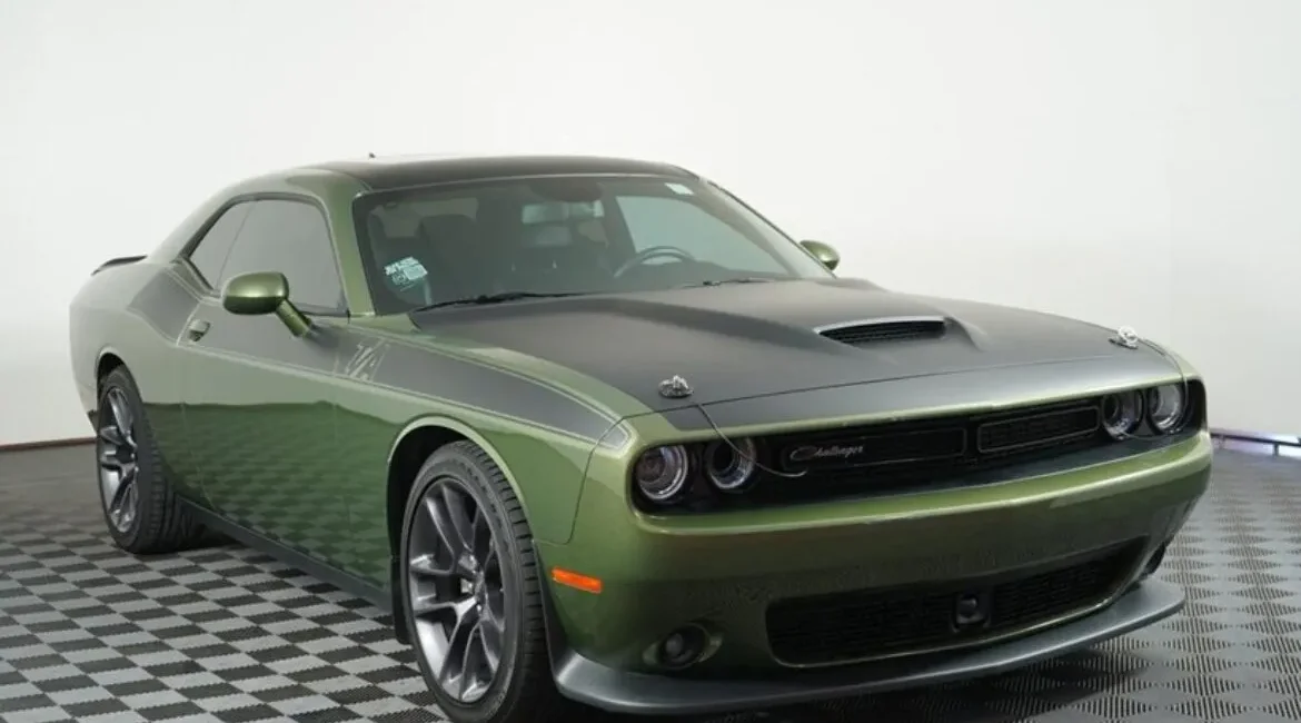 Green Dodge Challenger muscle car in showroom