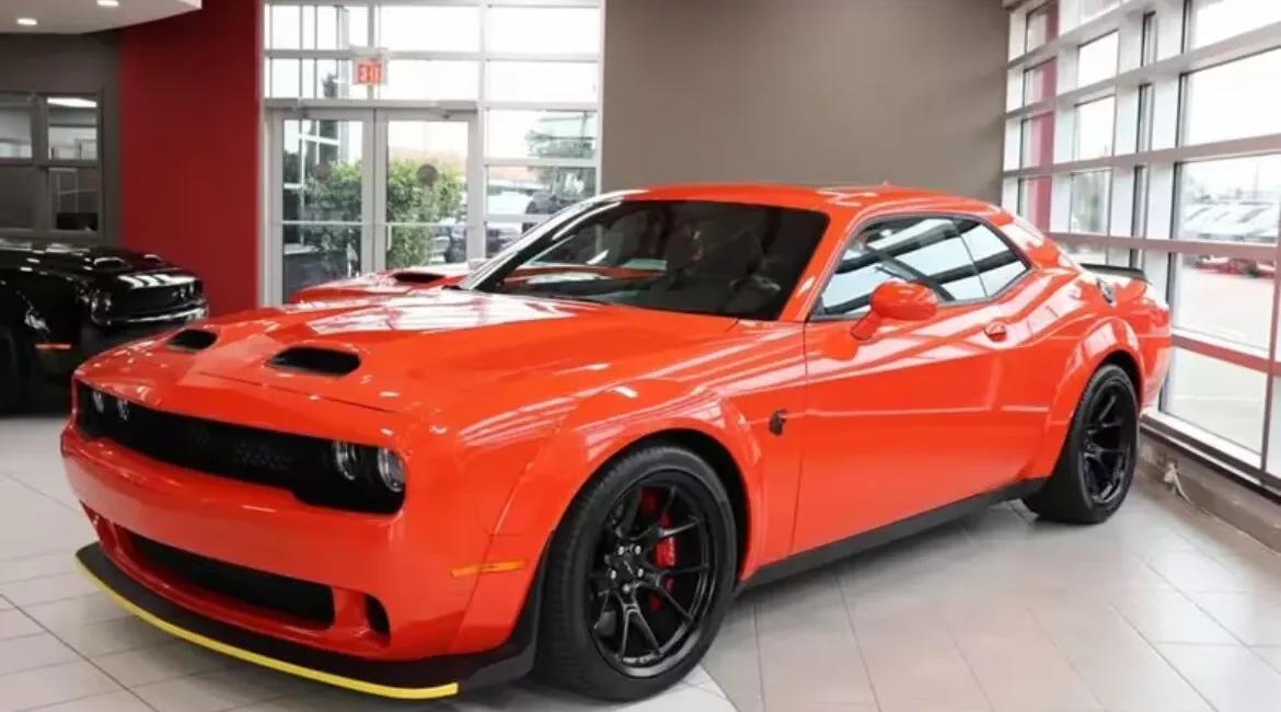 Bright orange muscle car in dealership showroom