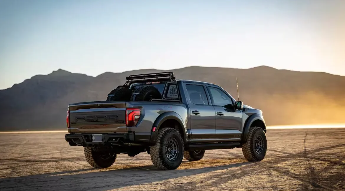 Off-road pickup truck on desert terrain at sunset