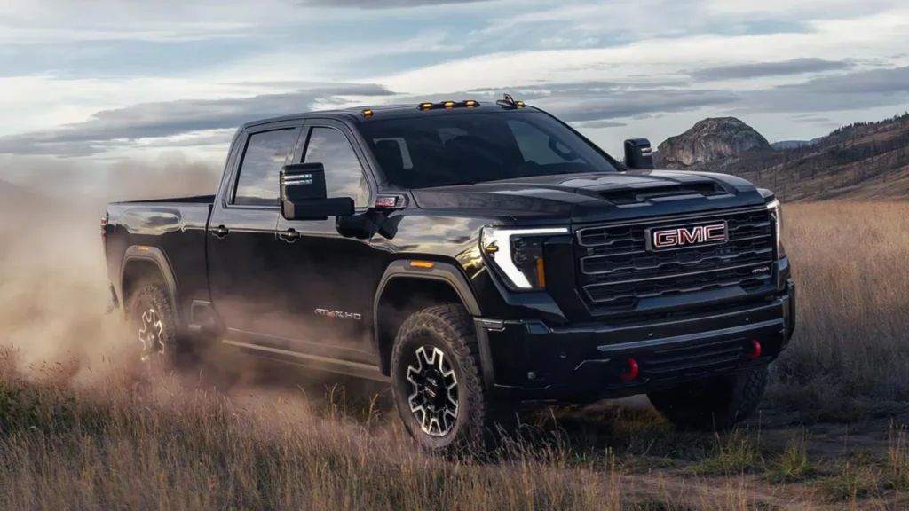 Black GMC truck driving off-road in dusty terrain
