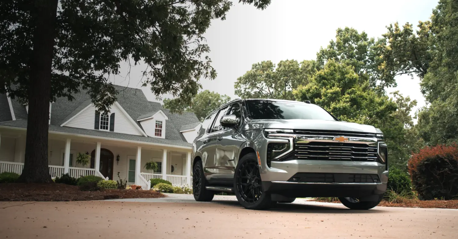 Black Widow Silver Chevrolet Tahoe SUV parked in front of house