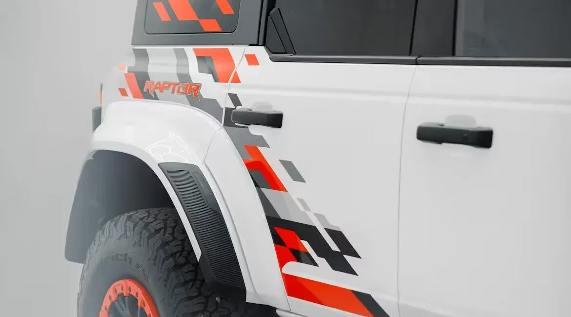 White off-road truck with orange graphic decals