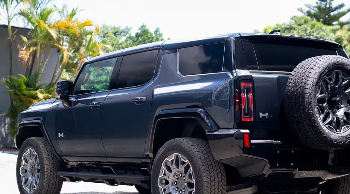 Black electric SUV parked outdoors near palm trees