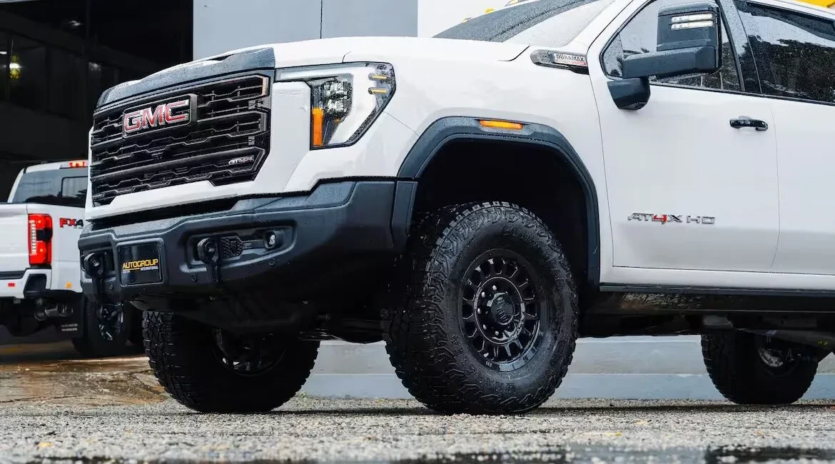 White GMC truck parked on wet pavement