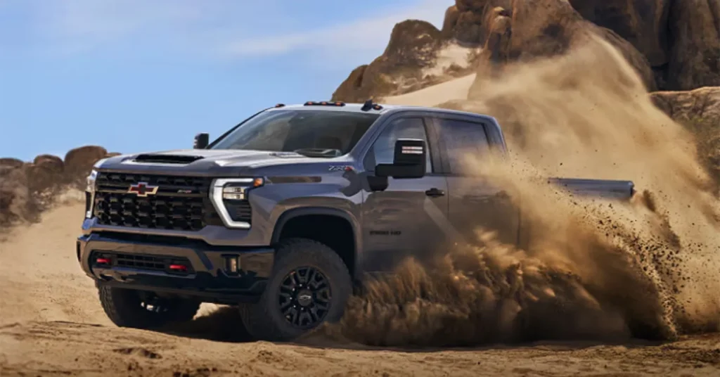 Pickup truck driving through desert sand dunes