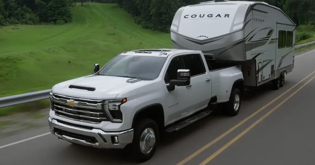 White pickup truck towing large Cougar RV trailer