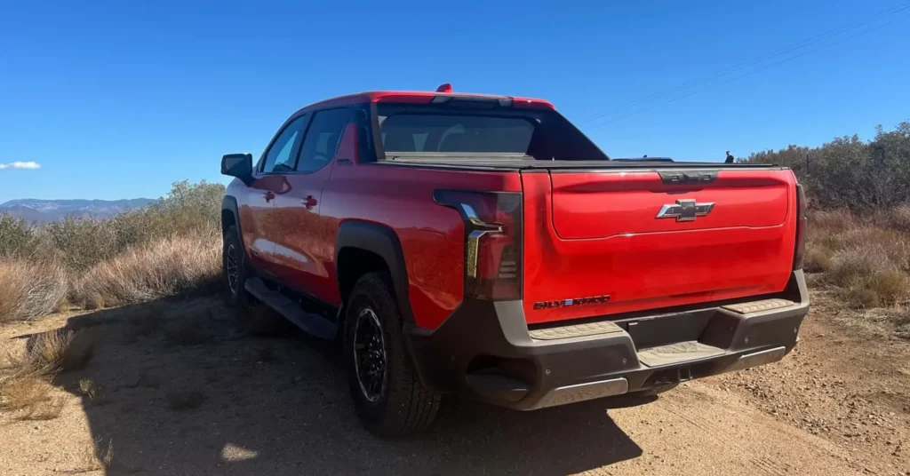 Red pickup truck parked on dirt road
