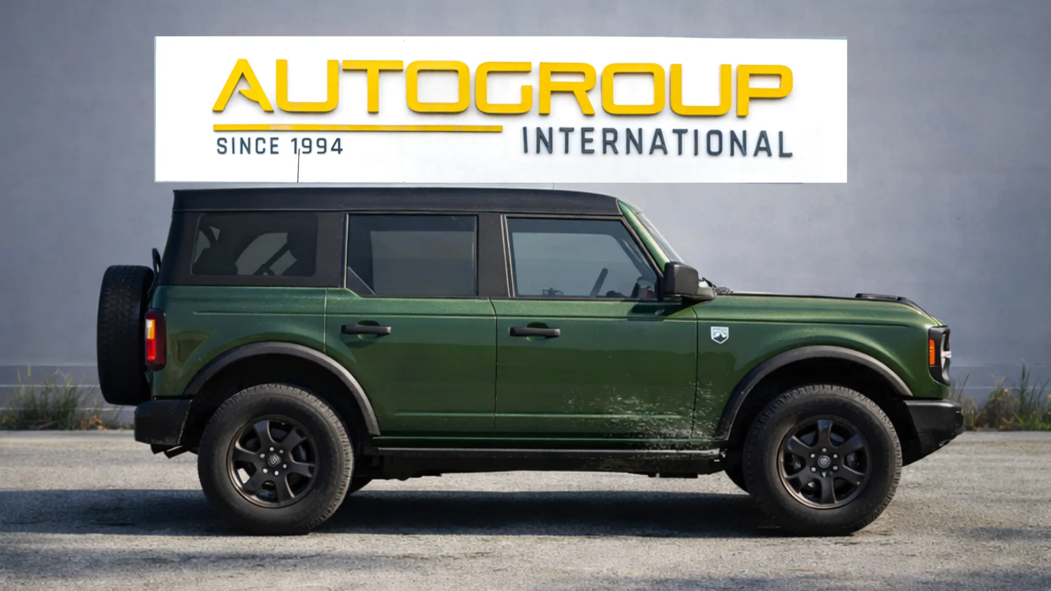 Green SUV parked near Autogroup International sign