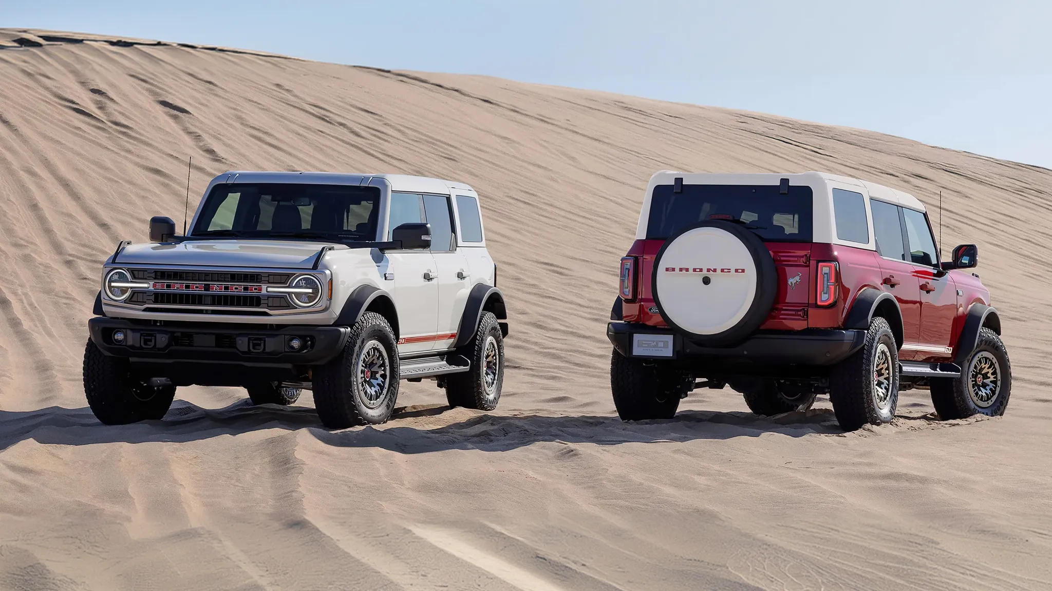 Two Ford Bronco SUVs on sand dunes