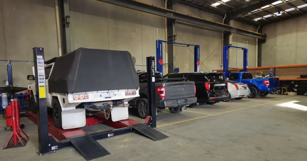 Vehicles on lifts inside auto repair shop