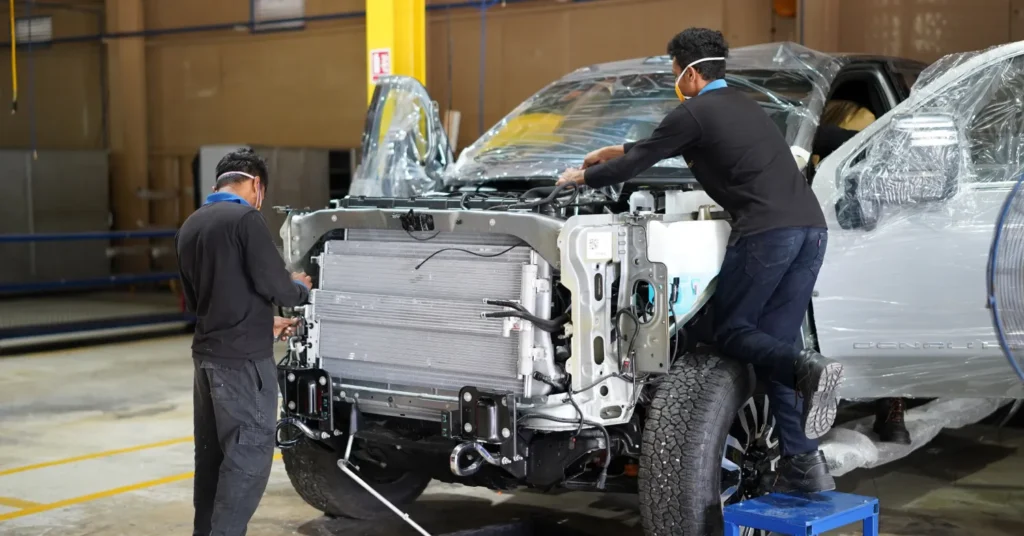 Workers assembling pickup truck in auto factory